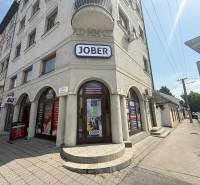 Commercial premises in Komárno on Petőfi Street with a sunny facade and advertising signs.