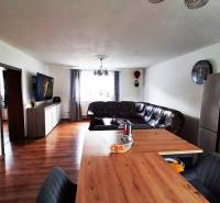 Living room in a family house with a leather sofa and a wall-mounted television.