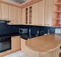 A wooden kitchen unit with black details in a family house.