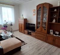 Living room in a 3-room apartment with a sofa, cabinet, and television, light decoration.