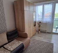 A room in a 3-room apartment with a sofa, wardrobe, and balcony.