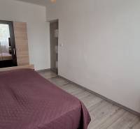 Bedroom with a bed, white walls, and a wardrobe, 3-room apartment.