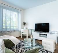 Living room in a two-room apartment with a large television and a designer table.
