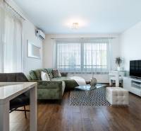 Living room in a two-room apartment with a sofa, a table, and a TV on a cabinet.