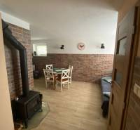 A family house with a brick wall, a fireplace stove, and a dining nook with wooden furniture.