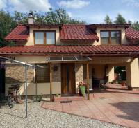 A family house on Liptovská Ondašová in Liptovský Mikuláš with a red roof and a garden seating area.