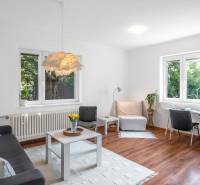 Bright living space in a 2-room apartment with a sofa, table, and desk.