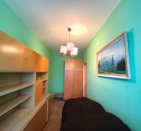A narrow room in a 3-room apartment with light furniture and a painting on the wall.