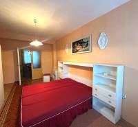 Bedroom in a 3-room apartment with a double bed, wardrobe, and wall decorations.