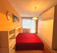 Bedroom with built-in wardrobes, bed with a red blanket in a 3-room apartment.