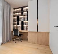 A workspace in a 3-room apartment with wooden flooring and designer lighting.