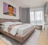 Bedroom in a 3-room apartment with a painting, a large bed, and a TV.