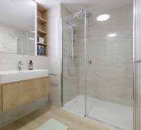 A bathroom with a double mirror, a shower cabin, and a wooden washbasin counter in a 3-room apartment.