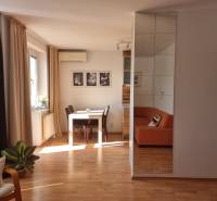 Living room in a 4-room apartment with a dining table and an orange sofa.