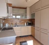 A kitchen in a 4-room apartment with wooden paneling and built-in appliances.
