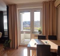 Dining room in a 4-room apartment with access to a balcony and a view of the city.