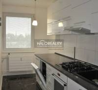 The kitchen in the 3-room apartment has white cabinets and a dark countertop.