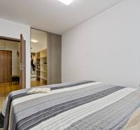 A bedroom with a bed, a book, a plush toy, and a built-in wardrobe in a 2-room apartment.
