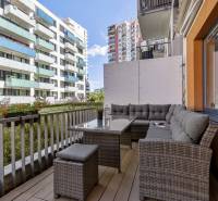 A balcony with seating in a 2-room apartment with a view of Bratislava's apartment buildings in Ružinov.