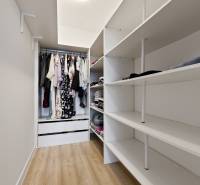 A wardrobe in a 2-room apartment with shelves and hanging space for clothes.
