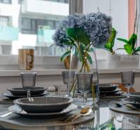 An elegantly set table with flowers in a 2-room apartment, glassware, and cutlery.