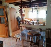 The interior of the cottage with wooden furniture, ceramic decorations, and pictures on the walls.