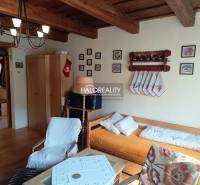 The interior of a cabin with a wooden ceiling, comfortable seating, and decorations on the wall.