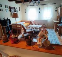 A cozy room in a cabin with a table, bed, and decorative items.