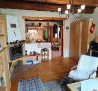 The interior of a cabin with a fireplace, wooden ceiling, cozy accessories, and comfortable furniture.