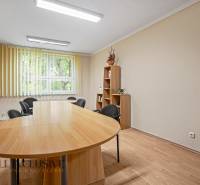 Dining table with a bookshelf and office chairs in the office.