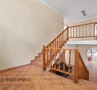 Office interior with wooden staircase and tiled floor.