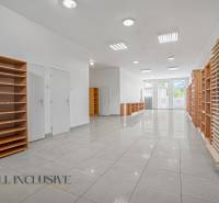 Interior of commercial premises with shelves and a well-lit entrance.
