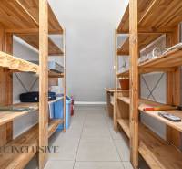 Wooden shelves in the storage area with various items on the tables.