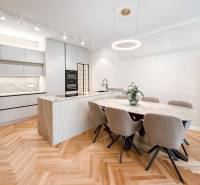Dining area with an oval table, six chairs, and a kitchen island in a 4-room apartment.