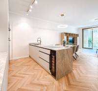 Living room and kitchen with an island in a 4-room apartment and wooden floors.