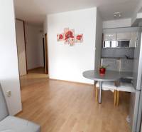 Interior of a 2-room apartment with wooden flooring and a kitchenette.