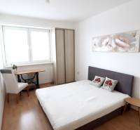 Bedroom in a two-room apartment with a bed, wardrobe, and desk.