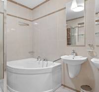 A bathroom in a 4-room apartment with a bathtub and two sinks.