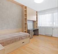 A bright room with a bed, a desk, and a window in a 4-room apartment.