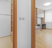 A wardrobe and a bright bedroom with wooden flooring in a 4-room apartment.