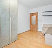 A room in a 4-room apartment with a wooden floor, a bed, and a built-in wardrobe.