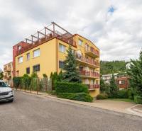Apartment building on Guothova Street in Bratislava - Kramáre, surrounded by greenery and cars.