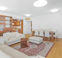 Living room in a 4-room apartment with sofas, a dining table, and a glass-fronted bookcase.