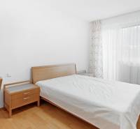 A bedroom with wooden furniture and a large window in a 4-room apartment.