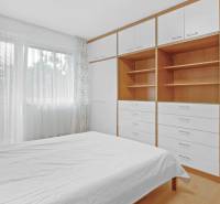 A bedroom in a 4-room apartment with a bed, built-in wardrobe, and a large window.