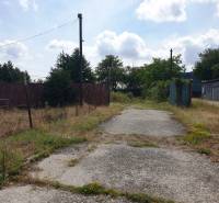 The reinforced road leads through commercial properties in Trenčianske Bohuslavice, surrounded by greenery.