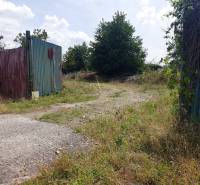 Entrance gate and overgrown land in Trenčianske Bohuslavice, suitable for commercial plots.