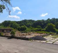 Commercial land on Lučenecká Road in Veľký Krtíš with an abandoned building, surrounded by trees.