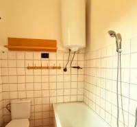 Bathroom in a family house with a bathtub, boiler, and toilet.