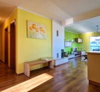 Interior of a vacation apartment with yellow walls, wooden flooring, and modern furniture.
